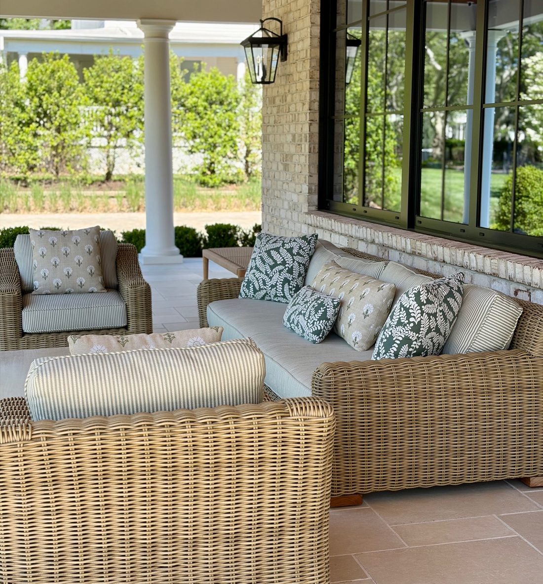 A curved sectional and low table on a poolside terrace at dusk