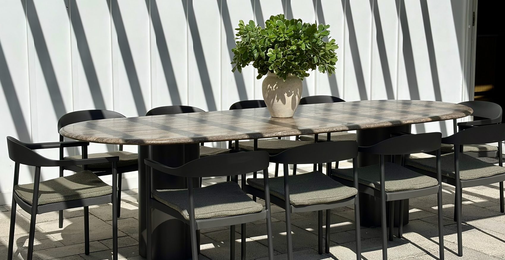 A long dining table set under the pergola