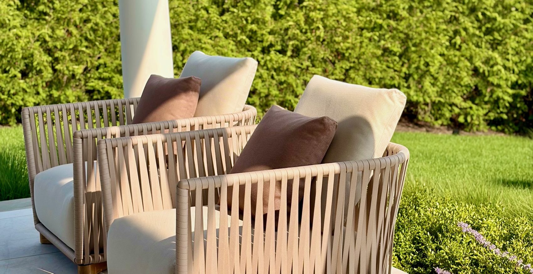 A pair of woven armchairs on the lawn
